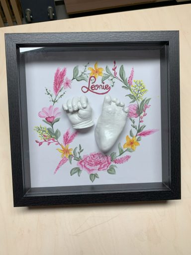 Kinderhand- und Fuß im Rahmen